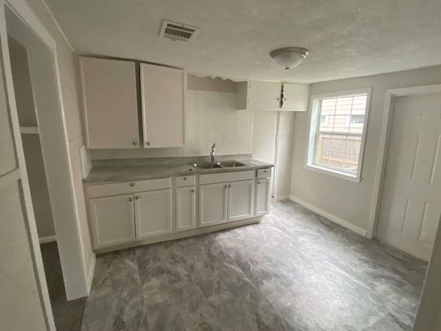 223 Cockerel St, Houston, TX 77018 - kitchen featuring white cabinetry, a textured ceiling, and light countertops