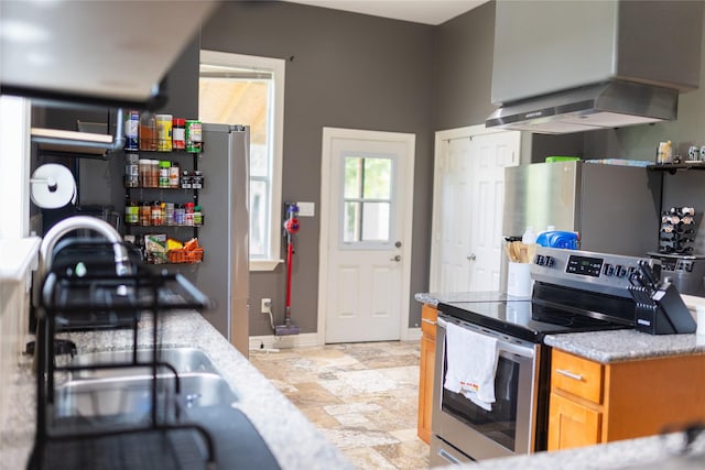 8309 Williamsdell St, Houston, TX 77088 - kitchen with stainless steel electric range, range hood, light stone finish flooring, freestanding refrigerator, and light countertops