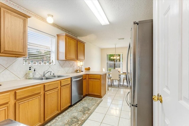 2210 Elm Forest Dr, Pearland, TX 77584 - kitchen with appliances with stainless steel finishes, backsplash, light countertops, light tile patterned floors, and a textured ceiling