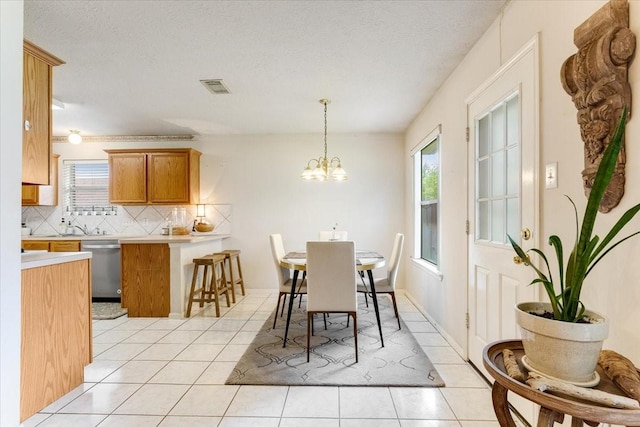 2210 Elm Forest Dr, Pearland, TX 77584 - dining space with light tile patterned floors, a chandelier, and a textured ceiling