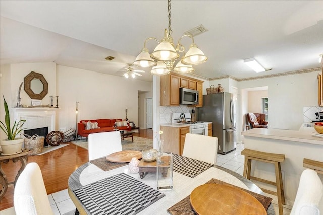 2210 Elm Forest Dr, Pearland, TX 77584 - dining room with light tile patterned floors, ceiling fan, and a high end fireplace