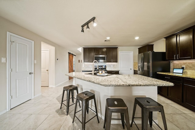 29023 Jacobs River Dr, Katy, TX 77494 - kitchen with stainless steel microwave, decorative backsplash, a kitchen breakfast bar, fridge with ice dispenser, and recessed lighting