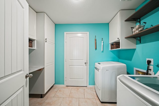 29023 Jacobs River Dr, Katy, TX 77494 - laundry room with cabinet space, light tile patterned floors, and washer and clothes dryer