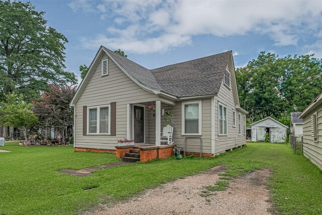 604 Abell St, Wharton, TX 77488 - bungalow with roof with shingles, a front yard, and an outdoor structure