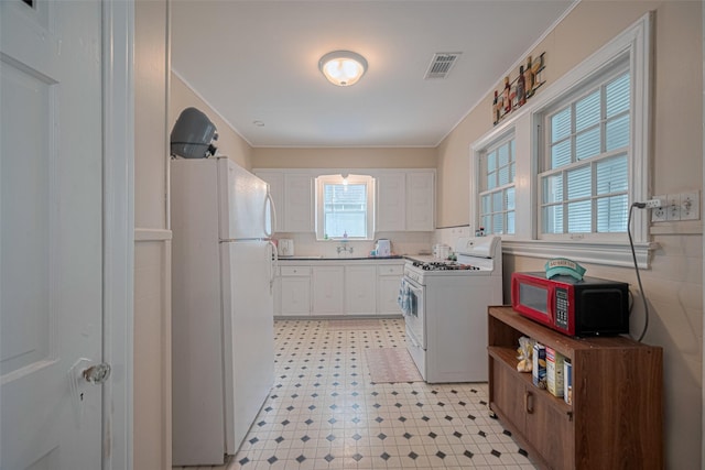 604 Abell St, Wharton, TX 77488 - kitchen with white appliances, white cabinetry, light flooring, light countertops, and crown molding