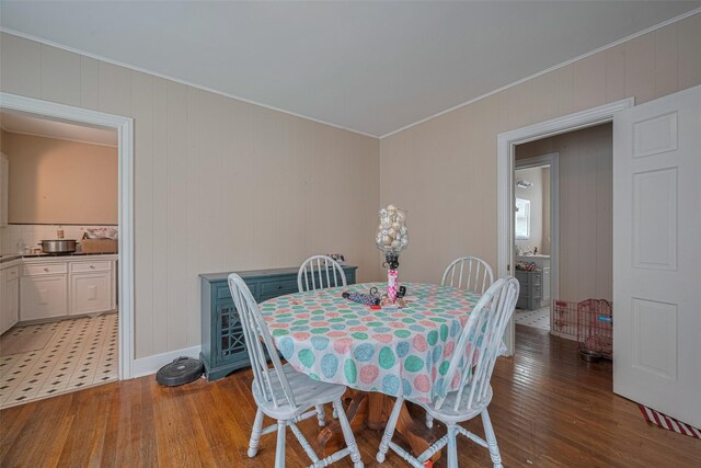 604 Abell St, Wharton, TX 77488 - dining room featuring light wood-style flooring, ornamental molding, and wood walls