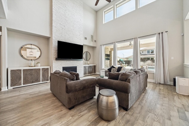 19526 Rock Quillwort Rd, Cypress, TX 77433 - living area with a ceiling fan, a towering ceiling, a fireplace, and wood finished floors