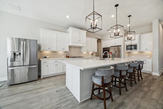 19526 Rock Quillwort Rd, Cypress, TX 77433 - kitchen with appliances with stainless steel finishes, a chandelier, decorative backsplash, white cabinetry, and recessed lighting