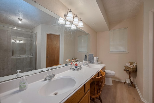 2017 Willow Bend Rd, Wharton, TX 77488 - bathroom featuring double vanity, a shower stall, wood finished floors, and a textured ceiling