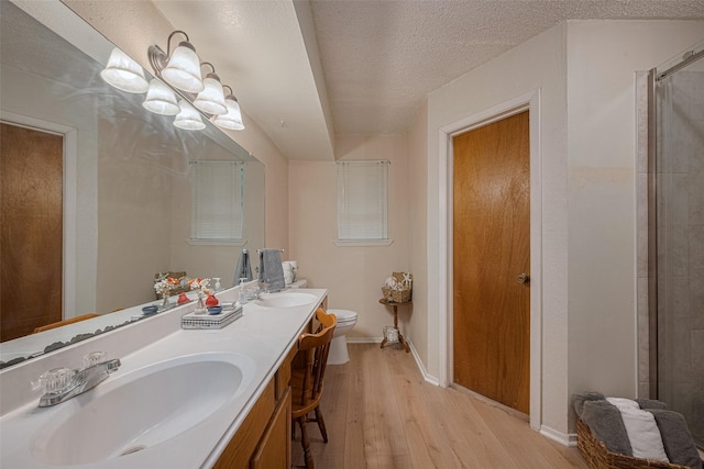 2017 Willow Bend Rd, Wharton, TX 77488 - full bath with wood finished floors, double vanity, tiled shower, a chandelier, and a textured ceiling