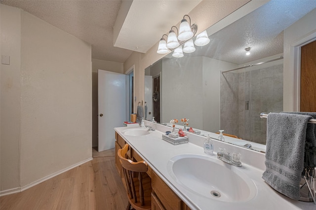 2017 Willow Bend Rd, Wharton, TX 77488 - bathroom featuring wood finished floors, double vanity, a textured ceiling, and a stall shower