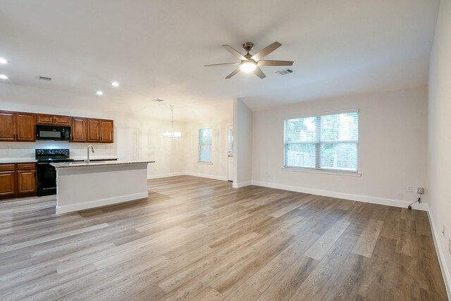 167 Courageous Side Way, Magnolia, TX 77354 - kitchen with black appliances, ceiling fan, open floor plan, a chandelier, and light wood-style floors