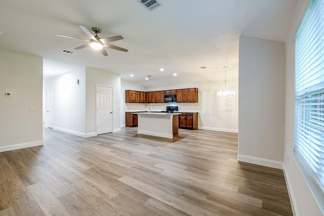167 Courageous Side Way, Magnolia, TX 77354 - unfurnished living room with a ceiling fan, plenty of natural light, light wood-type flooring, a chandelier, and lofted ceiling