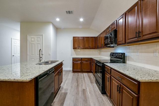 167 Courageous Side Way, Magnolia, TX 77354 - kitchen featuring black appliances, light wood-type flooring, decorative backsplash, light stone countertops, and recessed lighting