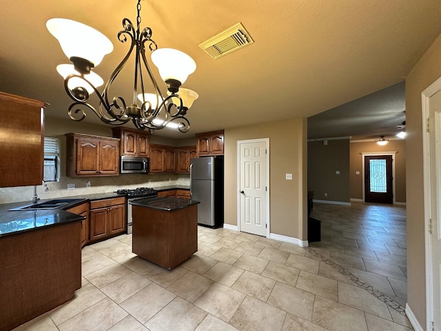 1040 Cardinal Dr, Richwood, TX 77566 - kitchen featuring appliances with stainless steel finishes, tasteful backsplash, a chandelier, a kitchen island, and plenty of natural light