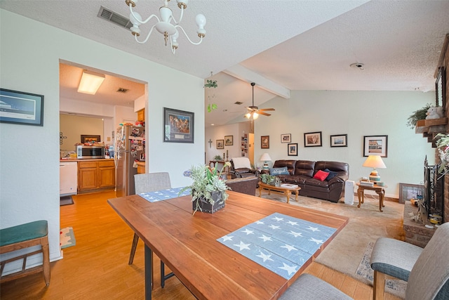 1805 Willow Bend Rd, Wharton, TX 77488 - dining space featuring light wood finished floors, a chandelier, a textured ceiling, and a ceiling fan