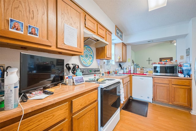 1805 Willow Bend Rd, Wharton, TX 77488 - kitchen with white appliances, under cabinet range hood, light wood-style flooring, and a textured ceiling