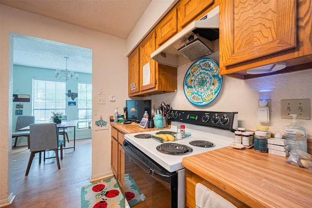 1805 Willow Bend Rd, Wharton, TX 77488 - kitchen with electric range, under cabinet range hood, a textured ceiling, brown cabinets, and a chandelier