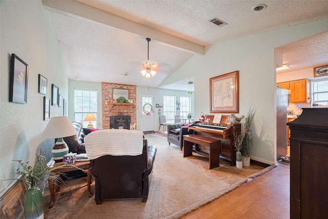 1805 Willow Bend Rd, Wharton, TX 77488 - living room with a textured ceiling, a ceiling fan, light wood-style flooring, a fireplace, and plenty of natural light