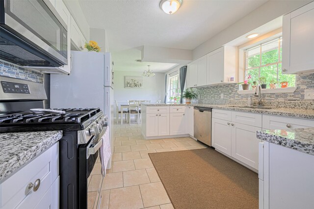 101 Wildrose St, Baytown, TX 77520 - kitchen with appliances with stainless steel finishes, healthy amount of natural light, backsplash, and white cabinets