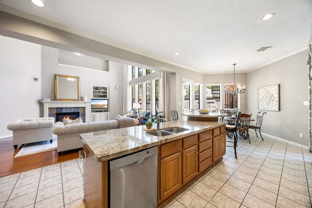 4607 Wellbrook Ln, Katy, TX 77450 - kitchen with stainless steel dishwasher, light tile patterned floors, crown molding, a chandelier, and an island with sink