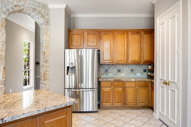 4607 Wellbrook Ln, Katy, TX 77450 - kitchen featuring stainless steel fridge, crown molding, decorative backsplash, brown cabinets, and arched walkways