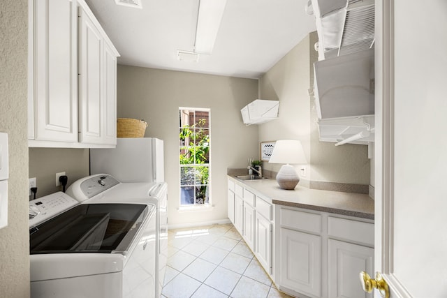 4607 Wellbrook Ln, Katy, TX 77450 - laundry room featuring cabinet space, washing machine and clothes dryer, and light tile patterned floors