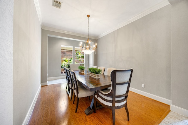 4607 Wellbrook Ln, Katy, TX 77450 - dining space with a chandelier, ornamental molding, and light wood-type flooring