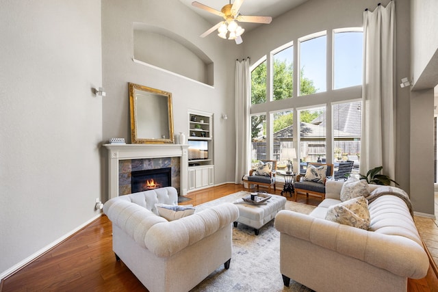 4607 Wellbrook Ln, Katy, TX 77450 - living area with a towering ceiling, a fireplace, a ceiling fan, wood finished floors, and built in features