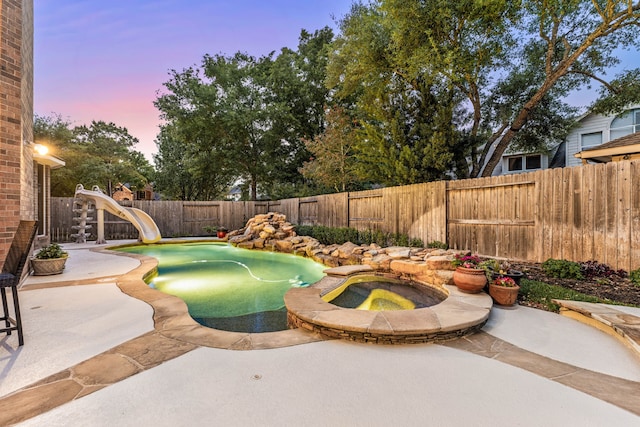 4607 Wellbrook Ln, Katy, TX 77450 - view of pool featuring a patio area, a water slide, a fenced backyard, and a pool with connected hot tub