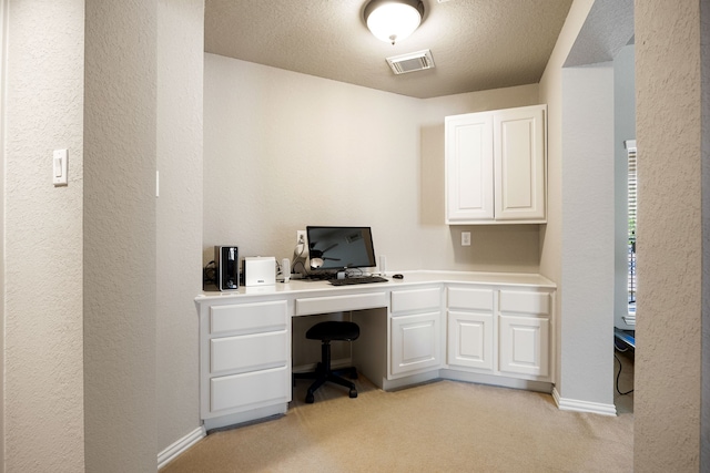 4607 Wellbrook Ln, Katy, TX 77450 - office area featuring built in study area, light colored carpet, a textured wall, and a textured ceiling