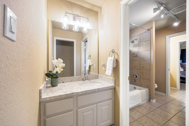 4607 Wellbrook Ln, Katy, TX 77450 - bathroom featuring tile patterned flooring,  shower combination, vanity, a textured wall, and track lighting