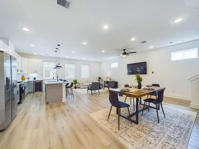 8319 Springwood Canyon Ln, Houston, TX 77055 - dining room with wine cooler, light wood finished floors, recessed lighting, and ceiling fan