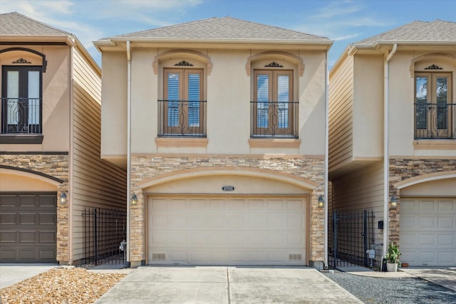 5708 Petty St Unit B, Houston, TX 77007 - view of front of house featuring stone siding, french doors, a garage, stucco siding, and driveway