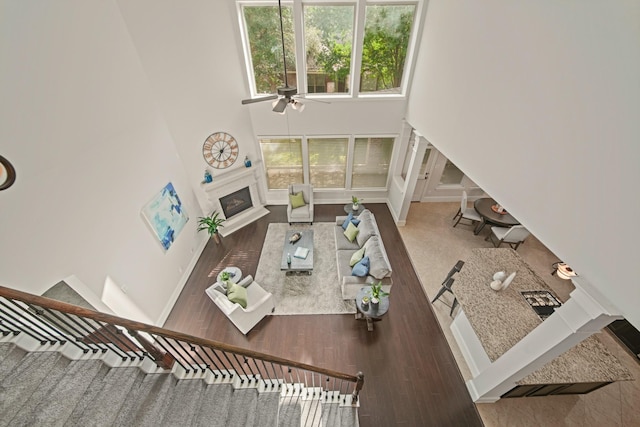 12102 N Founders Shore Dr, Cypress, TX 77433 - living area with a high ceiling, ceiling fan, a glass covered fireplace, and wood finished floors