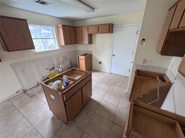 1629 Sylvia Ct, Round Rock, TX 78681 - kitchen with a textured ceiling, light tile patterned floors, and brown cabinets