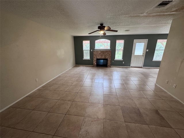 1629 Sylvia Ct, Round Rock, TX 78681 - unfurnished living room featuring a ceiling fan, a fireplace, a textured ceiling, and tile patterned flooring
