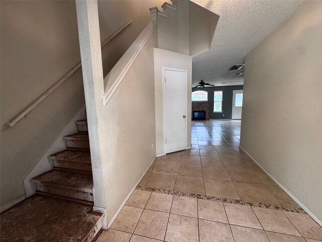 1629 Sylvia Ct, Round Rock, TX 78681 - stairs featuring a ceiling fan, tile patterned floors, and a textured ceiling