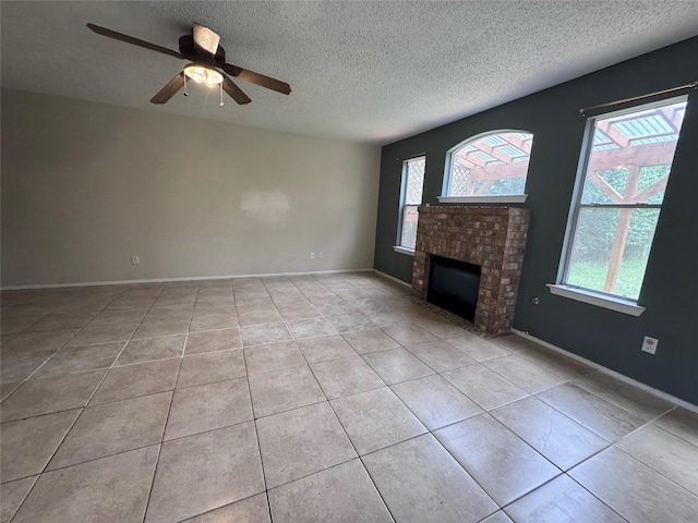 1629 Sylvia Ct, Round Rock, TX 78681 - unfurnished living room featuring a textured ceiling, light tile patterned floors, a ceiling fan, and a fireplace