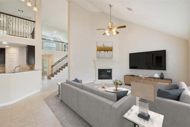 15315 Skyhill Dr, Cypress, TX 77433 - living room with high vaulted ceiling, a glass covered fireplace, ceiling fan, light tile patterned floors, and stairs