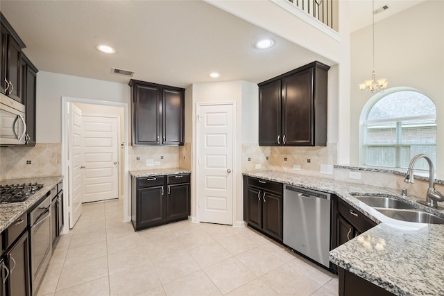 15315 Skyhill Dr, Cypress, TX 77433 - kitchen with appliances with stainless steel finishes, light stone countertops, decorative backsplash, dark brown cabinets, and recessed lighting
