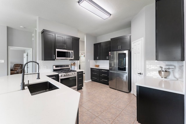 38318 E Sulphur Creek Dr, Magnolia, TX 77355 - kitchen featuring appliances with stainless steel finishes, backsplash, dark cabinets, light countertops, and light tile patterned floors