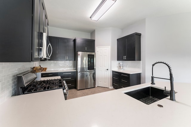 38318 E Sulphur Creek Dr, Magnolia, TX 77355 - kitchen featuring appliances with stainless steel finishes, backsplash, light countertops, light tile patterned flooring, and dark cabinets