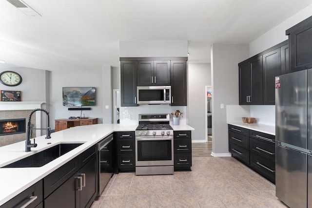 38318 E Sulphur Creek Dr, Magnolia, TX 77355 - kitchen with stainless steel appliances, dark cabinets, decorative backsplash, and light countertops