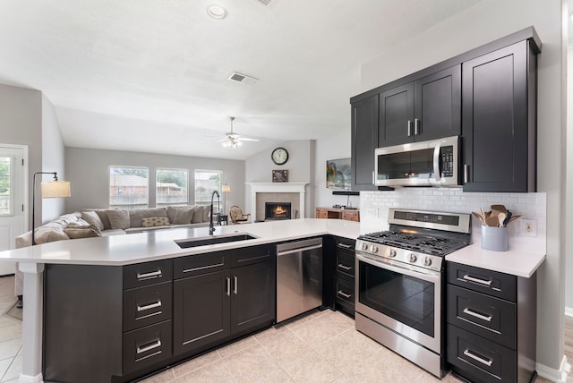 38318 E Sulphur Creek Dr, Magnolia, TX 77355 - kitchen with appliances with stainless steel finishes, a ceiling fan, open floor plan, a peninsula, and healthy amount of natural light
