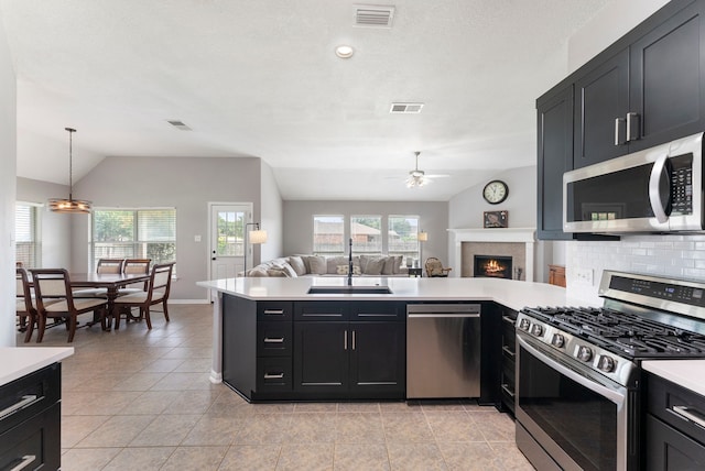 38318 E Sulphur Creek Dr, Magnolia, TX 77355 - kitchen featuring appliances with stainless steel finishes, vaulted ceiling, ceiling fan, open floor plan, and light countertops