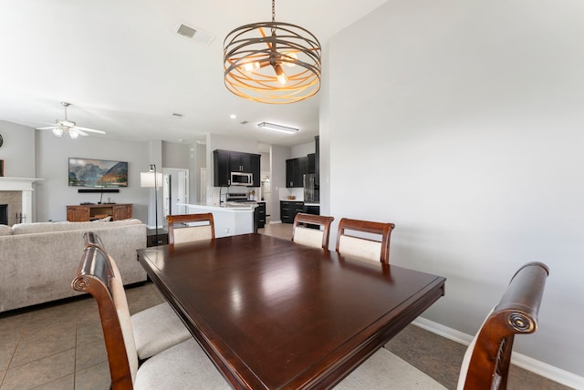 38318 E Sulphur Creek Dr, Magnolia, TX 77355 - dining area with a ceiling fan, light tile patterned flooring, a chandelier, and a tiled fireplace