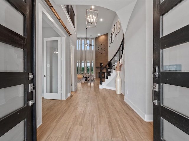 21310 Blue Wood Aster Ct, Cypress, TX 77433 - entryway with a chandelier, light wood finished floors, stairway, arched walkways, and recessed lighting