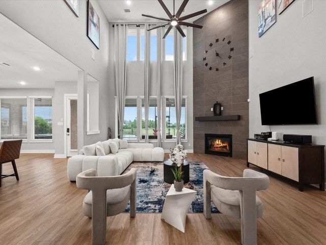 21310 Blue Wood Aster Ct, Cypress, TX 77433 - living area with a towering ceiling, a fireplace, wood finished floors, ceiling fan, and recessed lighting