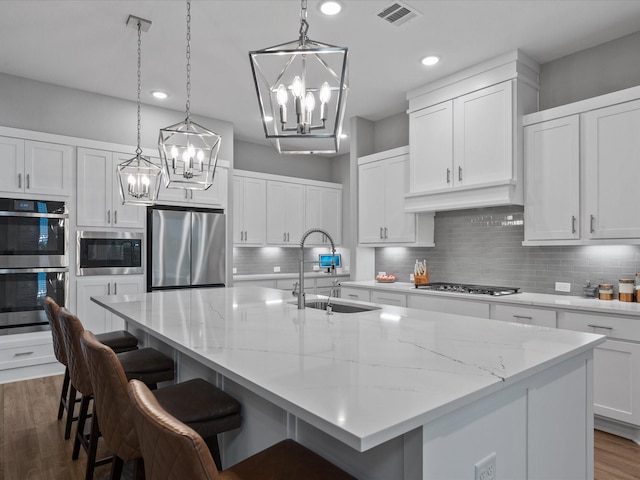 21310 Blue Wood Aster Ct, Cypress, TX 77433 - kitchen with stainless steel appliances, a chandelier, tasteful backsplash, dark wood finished floors, and recessed lighting